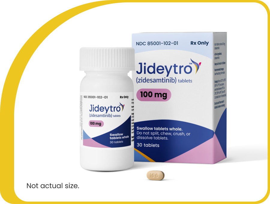 Jideytro (zidesamtinib) 100 mg tablets shown in a prescription bottle and carton, with one tablet in front