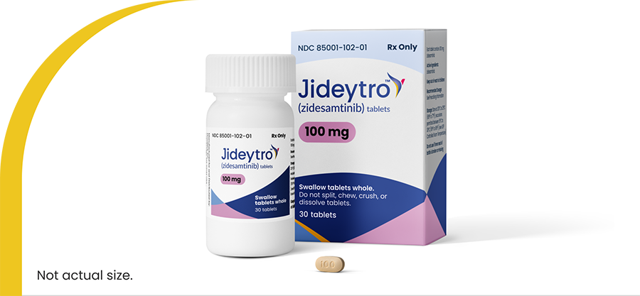 Jideytro (zidesamtinib) 100 mg tablets shown in a prescription bottle and carton, with one tablet in front
