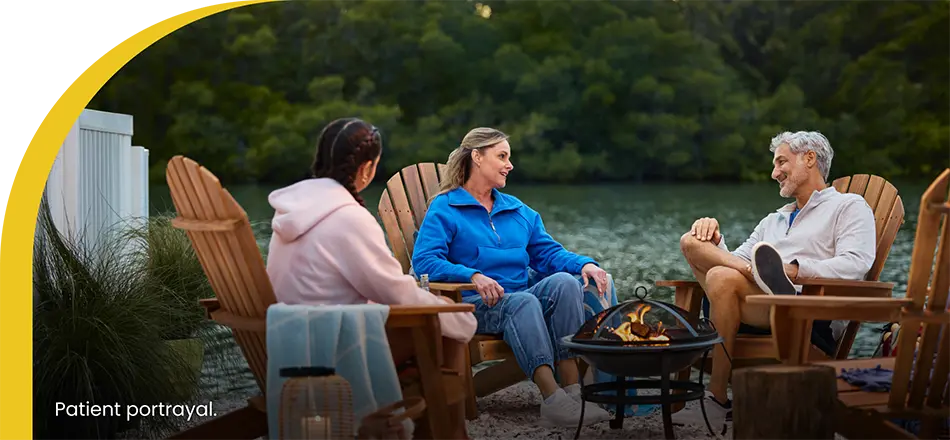 couple sitting with daughter around a campfire